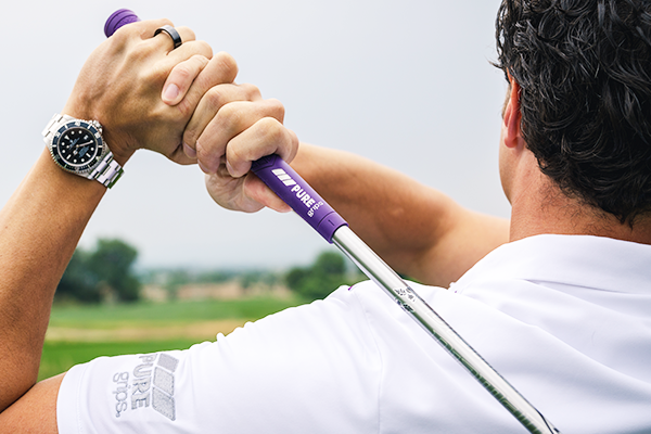 Man in white golf shirt on the backswing of a golf swing using the PURE DTX in Pitch Purple
